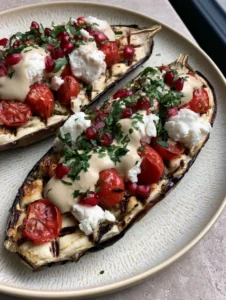 Two roasted eggplant halves with golden caramelized cross-hatch scored flesh and charred edges. (Mediterranean Roasted Eggplant)