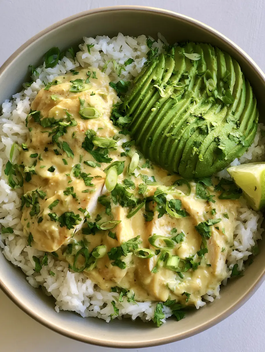 Coconut Chicken Rice Bowl with Creamy Lime and Avocado 3 A close up smartphone photo of a Coconut Chicken Rice Bowl in a ceramic bowl with lime and cilantro.