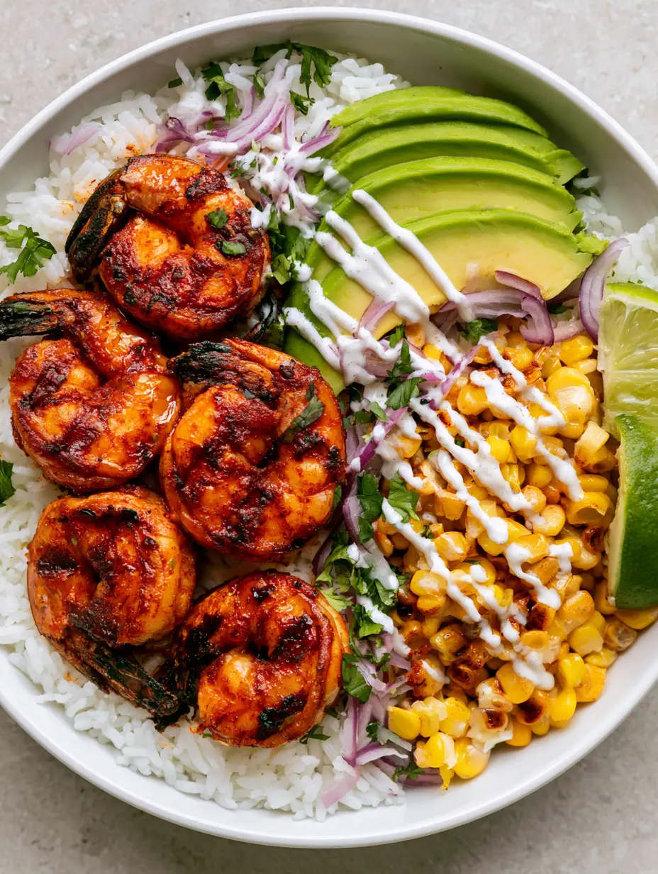 Close up of a Grilled Shrimp Bowl showing the glossy reddish-orange spice rub on the shrimp and roasted corn with toasted edges.