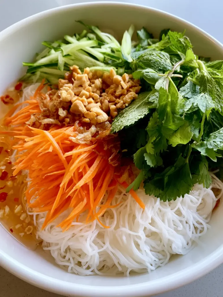 Vietnamese Noodle Salad: The Ultimate Refreshing Summer Bowl 1 A handheld smartphone photo showing a finished Vietnamese Noodle Salad with peanuts and fried shallots.