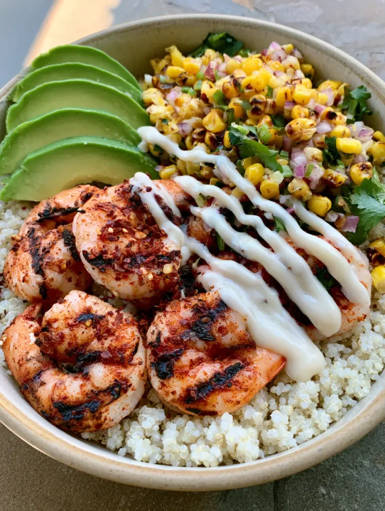 Close up of charred grilled shrimp with red chili flakes and a thick creamy white garlic sauce in a Grilled Shrimp Bowl.