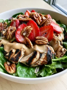 Top-down view of Strawberry Pecan Chicken Salad with distinct grill marks on the chicken and vibrant sliced strawberries.