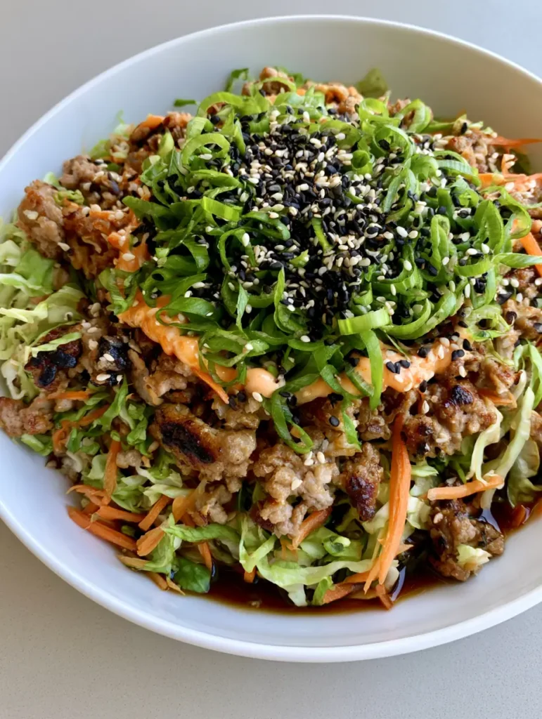 Egg Roll in a Bowl: The Ultimate 15-Minute Crack Slaw Recipe 2 Overhead smartphone photo of Egg Roll in a Bowl in a white ceramic bowl showing glossy sauce and sesame seeds.