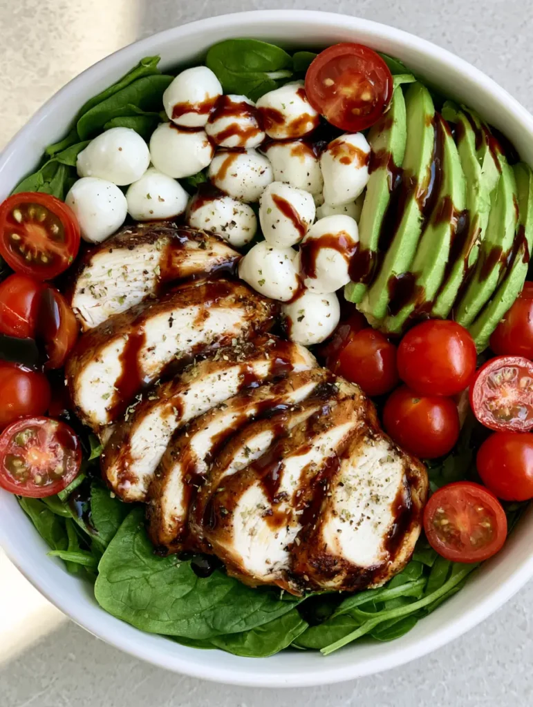 Close up of sliced oven-baked chicken breast and mozzarella pearls in a Baked Chicken Salad.
