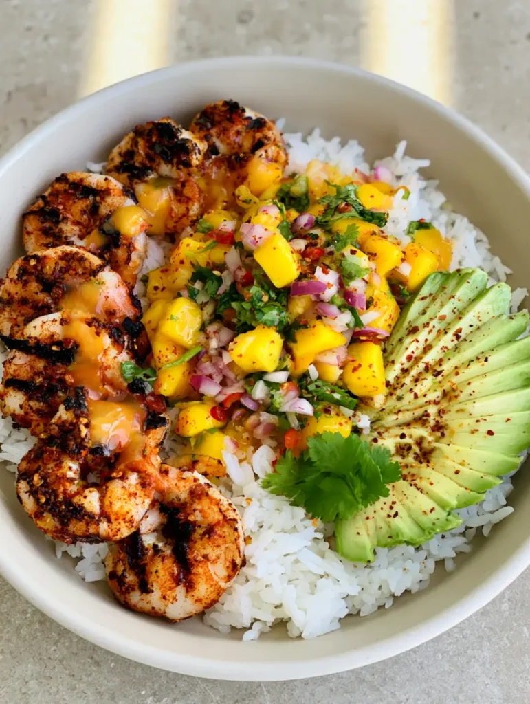 Healthy Shrimp and Avocado Bowls with Zesty Mango Salsa 1 A side view of the Healthy Shrimp and Avocado Bowls showing the lime-chili glaze drizzle.