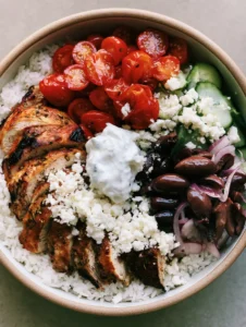 A detailed close-up of Mediterranean Chicken Meal Prep featuring golden-brown grilled chicken and feta cheese. (Mediterranean Chicken Meal Prep)
