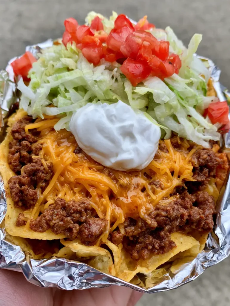 Vacation Meal Ideas: The Ultimate Easy Walking Tacos for Busy Trips 1 Walking taco with vibrant red tomatoes and pale green lettuce in a crinkled foil bag.