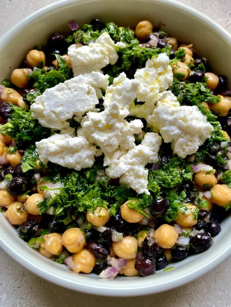 Top-down view of Chickpea and Black Bean Salad with glistening lime oil and fresh cilantro.