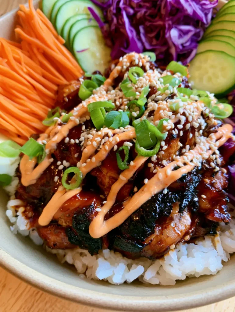 Korean BBQ Chicken Bowls with Dark Mahogany Glaze 1 Smartphone photo of Korean BBQ Chicken Bowls in a ceramic dish with vibrant vegetable sections and spicy mayo ribbons.