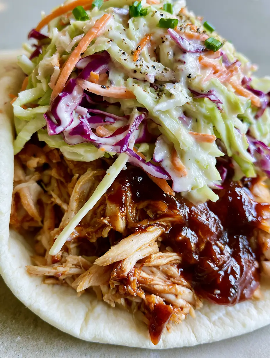 BBQ Chicken Coleslaw Wraps: The Ultimate 15-Minute Recipe 3 Close up of shredded rotisserie chicken in a thick mahogany BBQ sauce inside a flour tortilla. (BBQ Chicken Coleslaw Wraps)
